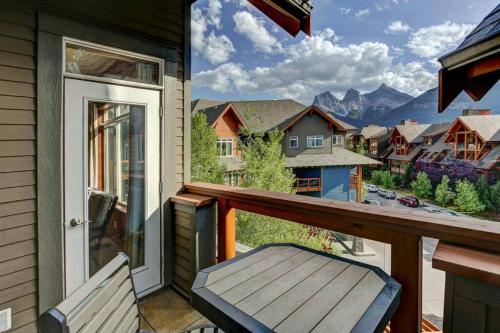 a balcony with a bench and a view of the mountains at Sun Drenched Escape in Canmore