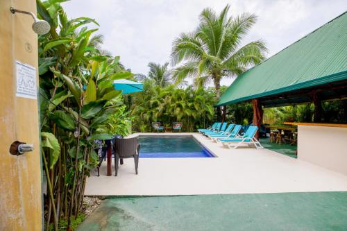 a pool at a resort with chairs and a table at Casa Plumeria-Aloha Surf Nosara in Nosara