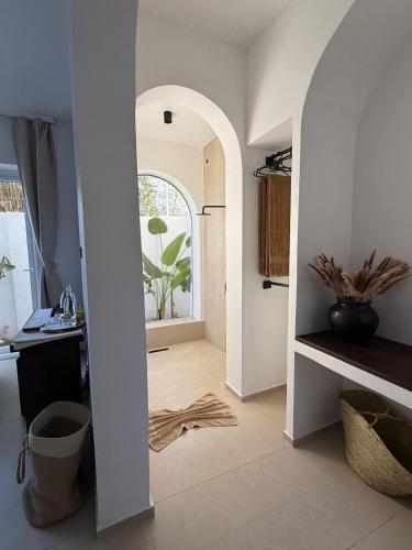a hallway with an archway leading to a kitchen with a plant at Kuwa Zanzibar in Kiwengwa