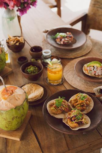 a wooden table with plates of food on it at Casa Yuma, Puerto Escondido in Puerto Escondido