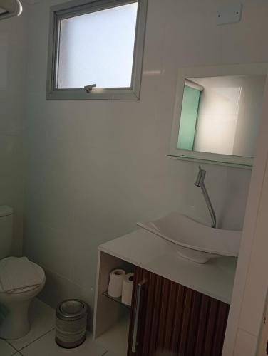 a bathroom with a sink and a toilet and a window at San Marino Hotel in São José dos Campos