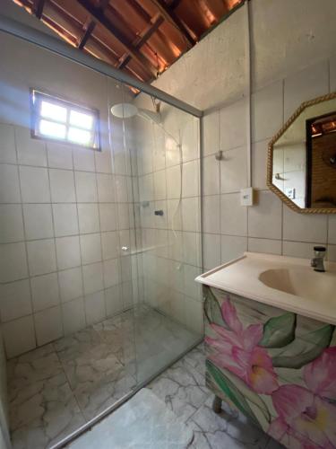a bathroom with a shower and a sink and a mirror at Refúgio mar aberto BA in Alcobaça