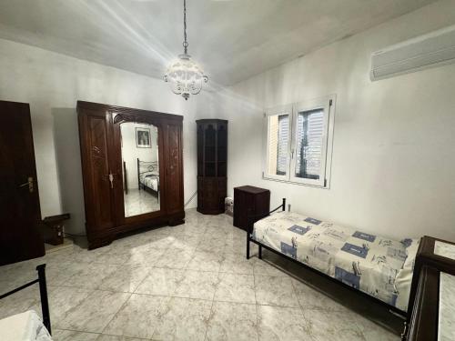 a bedroom with a bed and a mirror and a chandelier at LocusAmoenus in Plemmirio
