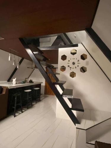 a staircase in a room with a kitchen and a bar at Lilys Cabin in Infanta