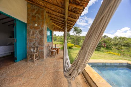 una hamaca en el porche de una casa con piscina en Buratá Haus Hotel Boutique, en Barichara