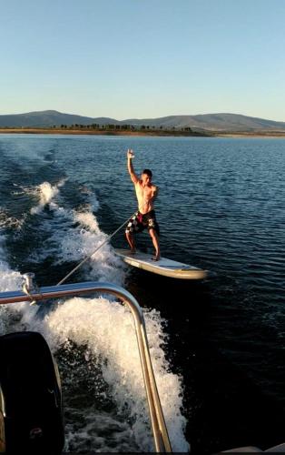 a man on a board in the water on a boat at Akassa Alojamientos Bioclimaticos en las Hurdes in Pinofranqueado