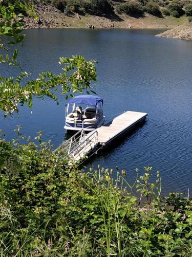 a boat parked at a dock on a lake at Akassa Alojamientos Bioclimaticos en las Hurdes in Pinofranqueado