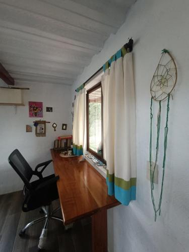 a room with a desk and a chair and a window at El Mango - rural house with fast internet in San Cristobal
