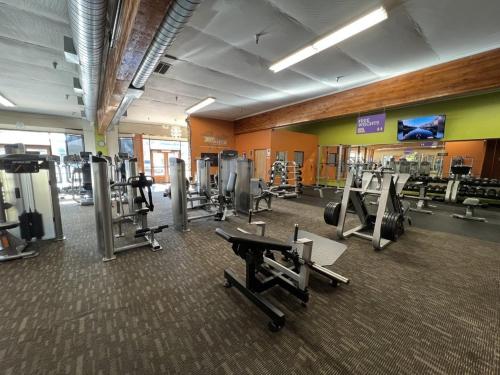 a gym with treadmills and machines in a room at The Queen On Main in Winters