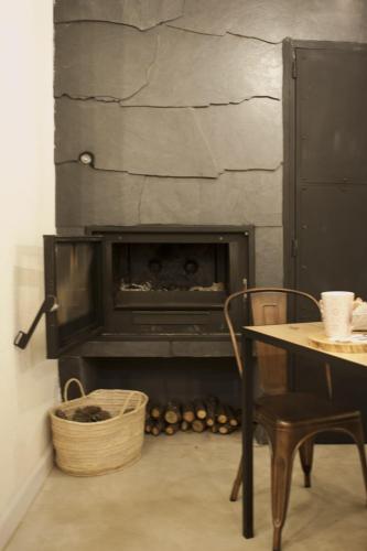 a fireplace in a room with a table and a tableablish at Akassa Alojamientos Bioclimaticos en las Hurdes in Pinofranqueado