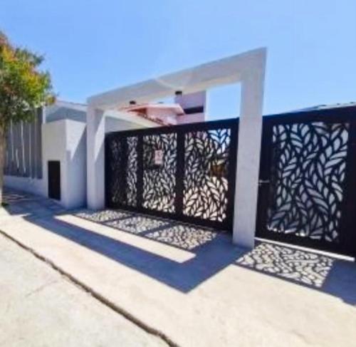 a house with a black iron gate on a street at Monoambiente a estrenar ubicado en el centro de la Falda in La Falda