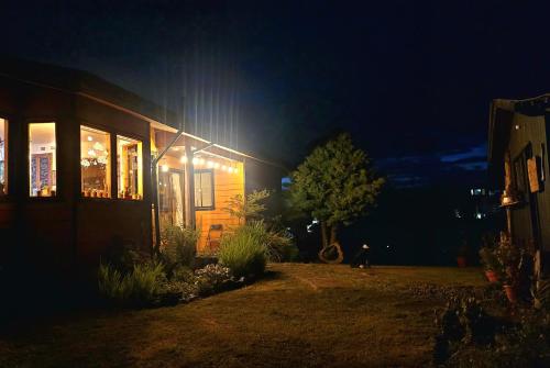 a house at night with a person walking in front of it at Hostal Boutique El Vergel Azul in Castro