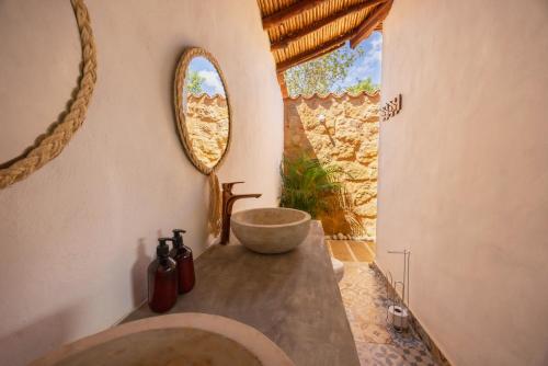 Un baño con lavabo y un espejo grande. en Buratá Haus Hotel Boutique, en Barichara