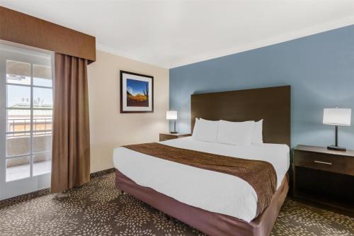 a hotel room with a large bed and a window at Best Western InnSuites Tucson Foothills Hotel & Suites in Tucson