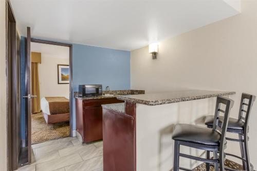 a kitchen with a counter and chairs in a room at Best Western InnSuites Tucson Foothills Hotel & Suites in Tucson