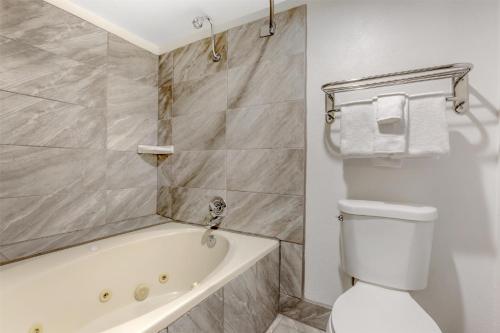 a bathroom with a tub and a toilet and a sink at Best Western InnSuites Tucson Foothills Hotel & Suites in Tucson