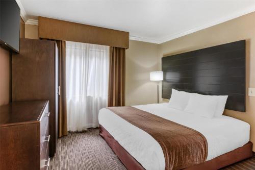a hotel room with a large bed and a television at Best Western InnSuites Tucson Foothills Hotel & Suites in Tucson