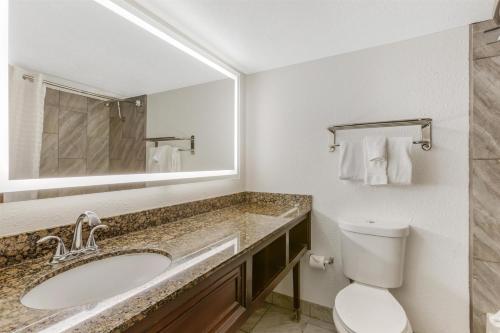 a bathroom with a sink and a toilet and a mirror at Best Western InnSuites Tucson Foothills Hotel & Suites in Tucson