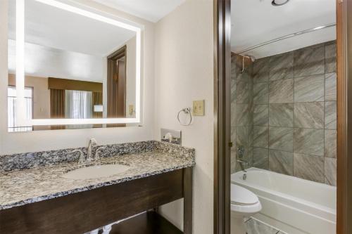a bathroom with a sink and a toilet and a mirror at Best Western InnSuites Tucson Foothills Hotel & Suites in Tucson
