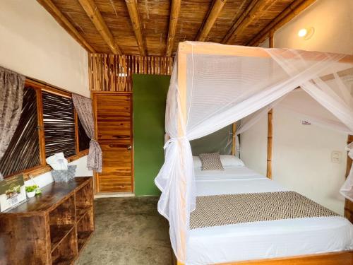 a bedroom with a bed with a mosquito net at Rincon del Mar Palomino in Palomino