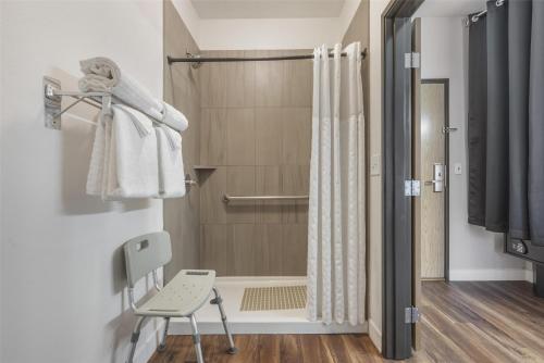 a bathroom with a shower and a chair at Best Western Plus Columbia River Inn in Cascade Locks