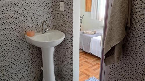 Un baño con lavabo y una cama en una habitación. en Studio Marola, Aconchego na Rua Mais Charmosa, en Itacaré