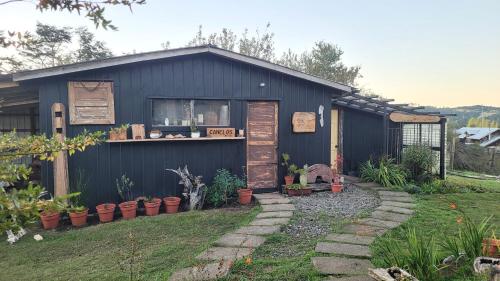 a blue building with a window and plants in a yard at Hostal Boutique El Vergel Azul in Castro