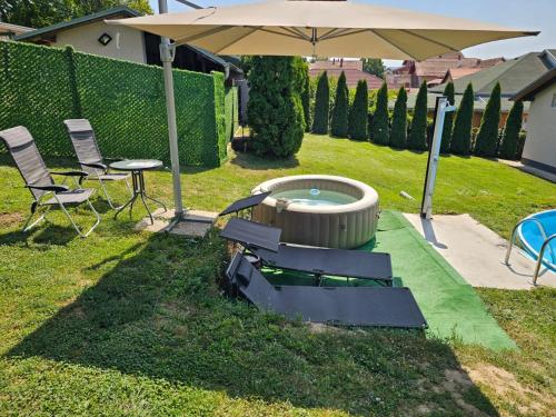 a patio with a table and chairs and an umbrella at Violeta guest house in Petrovaradin