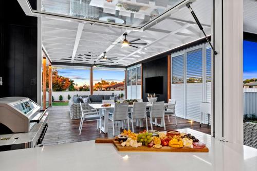 an open kitchen and dining room with a table and chairs at The Manor Bargara in Bargara