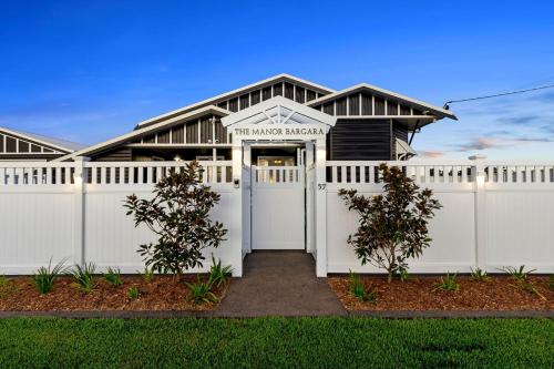 a white fence in front of a house at The Manor Bargara in Bargara