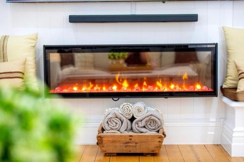 a fireplace in a living room with orange flames at The Manor Bargara in Bargara