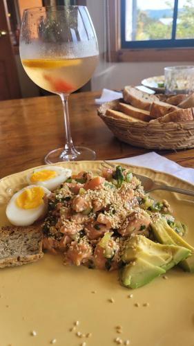 a plate of food with eggs and broccoli and a drink at Hostal Boutique El Vergel Azul in Castro