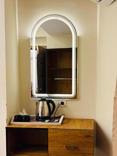 a mirror on top of a wooden dresser in a room at The View Pyramids Gold Two in Cairo