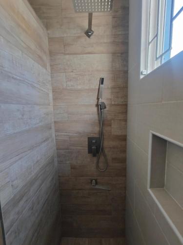 a shower in a bathroom with wooden tiles at Haven in Meadowbrook in Kingston