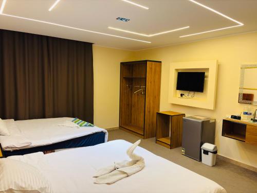 a hotel room with two beds and a television at The View Pyramids Gold Two in Cairo