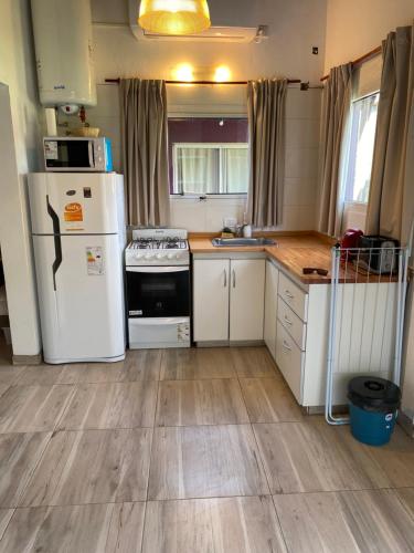a kitchen with white appliances and wooden floors at Villa La Soñada in Miramar