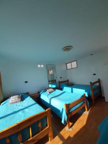 a room with two beds and a mirror at Hostal Pampaloja Antof in Antofagasta