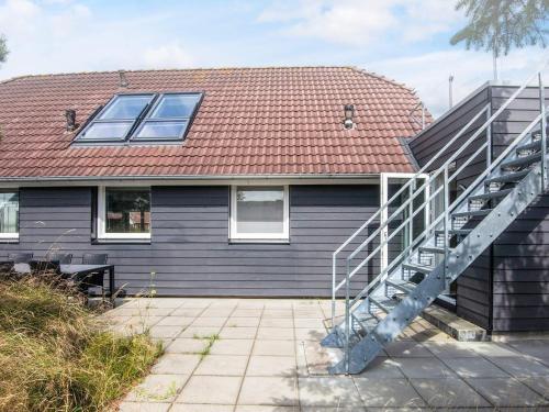 a house with a metal staircase in front of it at 4 star holiday home in Nørre Nebel in Nørre Nebel