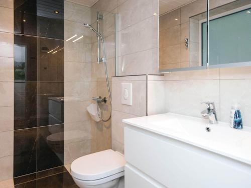 a bathroom with a toilet and a sink and a shower at 4 star holiday home in Nørre Nebel in Nørre Nebel