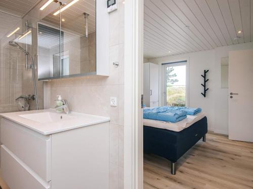a bathroom with a bed and a sink and a mirror at 4 star holiday home in Nørre Nebel in Nørre Nebel