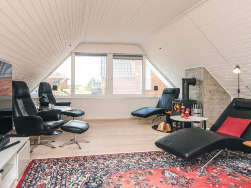 a living room with black chairs and a rug at 4 star holiday home in Nørre Nebel in Nørre Nebel