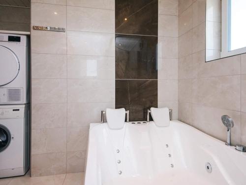 a bathroom with a tub and a washing machine at 4 star holiday home in Nørre Nebel in Nørre Nebel