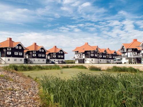 a row of houses on the beach with cars parked at 5 person holiday park in Bogense in Bogense