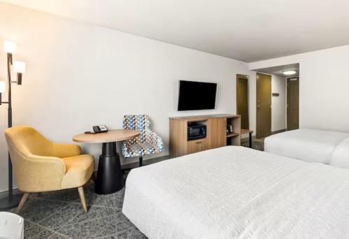 a hotel room with a bed and a chair and a tv at Hampton Inn and Suites Merced in Merced