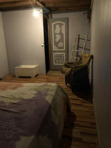 a bedroom with a bed and a chair and a ladder at Chez Hina no Pacifica in Bora Bora
