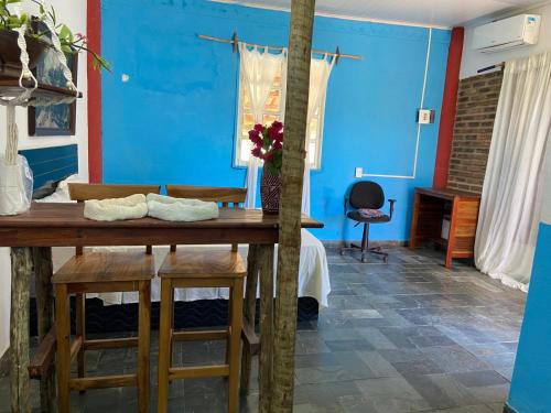 a blue room with a wooden table and stools at Refúgio mar aberto BA in Alcobaça