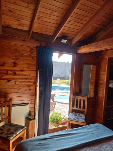 una camera con letto e vista sulla piscina di Cabañas Diamante a Gualeguaychú