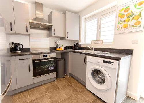 a kitchen with a washing machine and a dishwasher at Premium Contractors House near M6 J3 & CBS Arena in Coundon