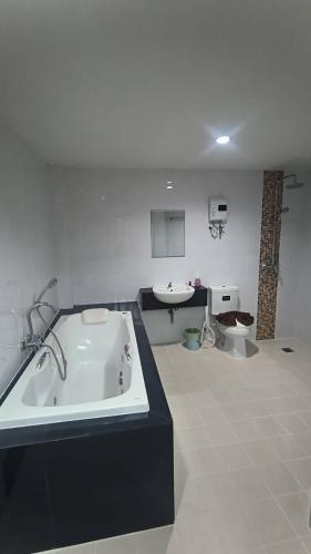 a bathroom with a bath tub and a sink at Ao Nang 9 Rooms and Stay in Ao Nang 
