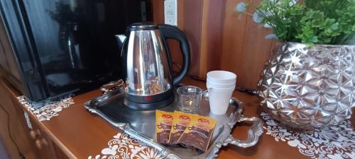 a coffee maker on a tray on a table with a vase at Morada das Mandalas in Pomerode